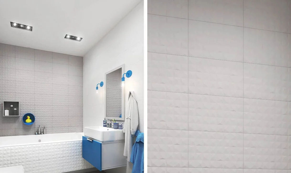 Nowoczesna łazienka z białymi i jasnoszarymi płytkami kamieniopodobnymi z geometrycznym wzorem i niebieskimi akcentami.