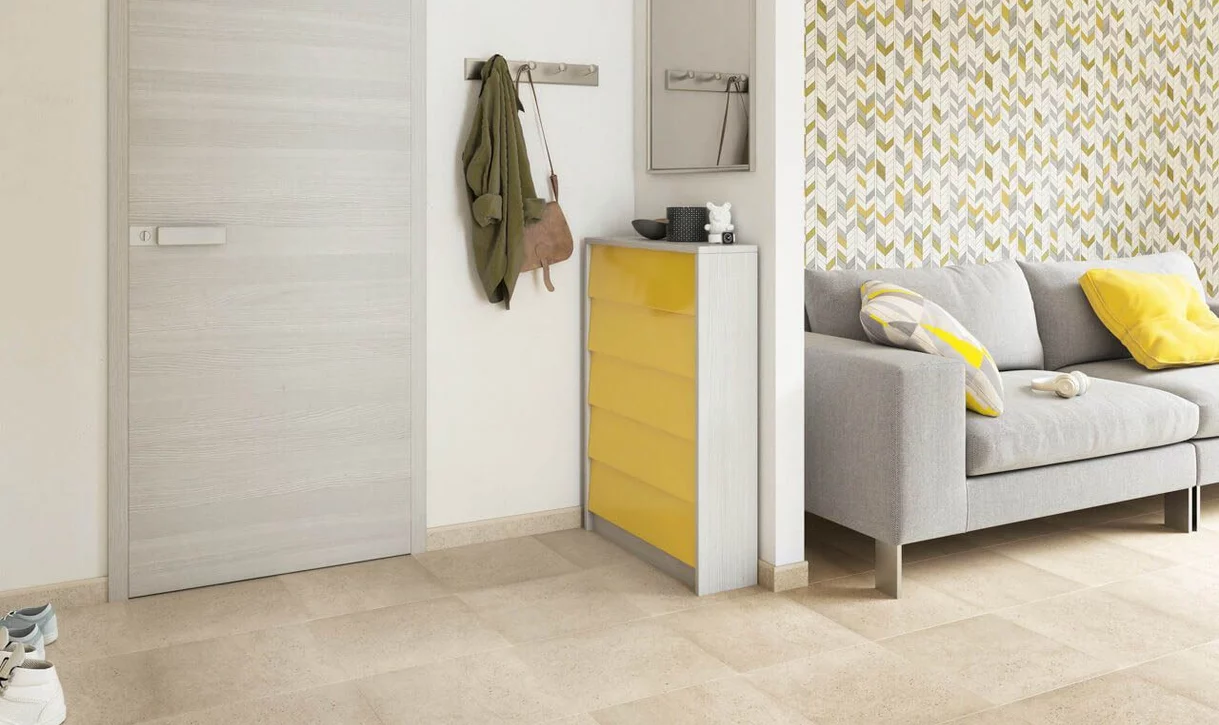 Nowoczesny salon z beżowymi płytkami kamieniopodobnymi na podłodze i geometryczną ścianą akcentową.