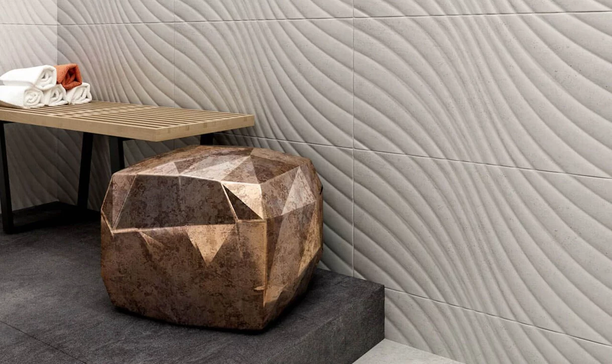 Nowoczesne wnętrze z jasnoszarymi ceramicznymi płytkami ściennymi z falistym wzorem i ciemnoszarymi płytkami podłogowymi.