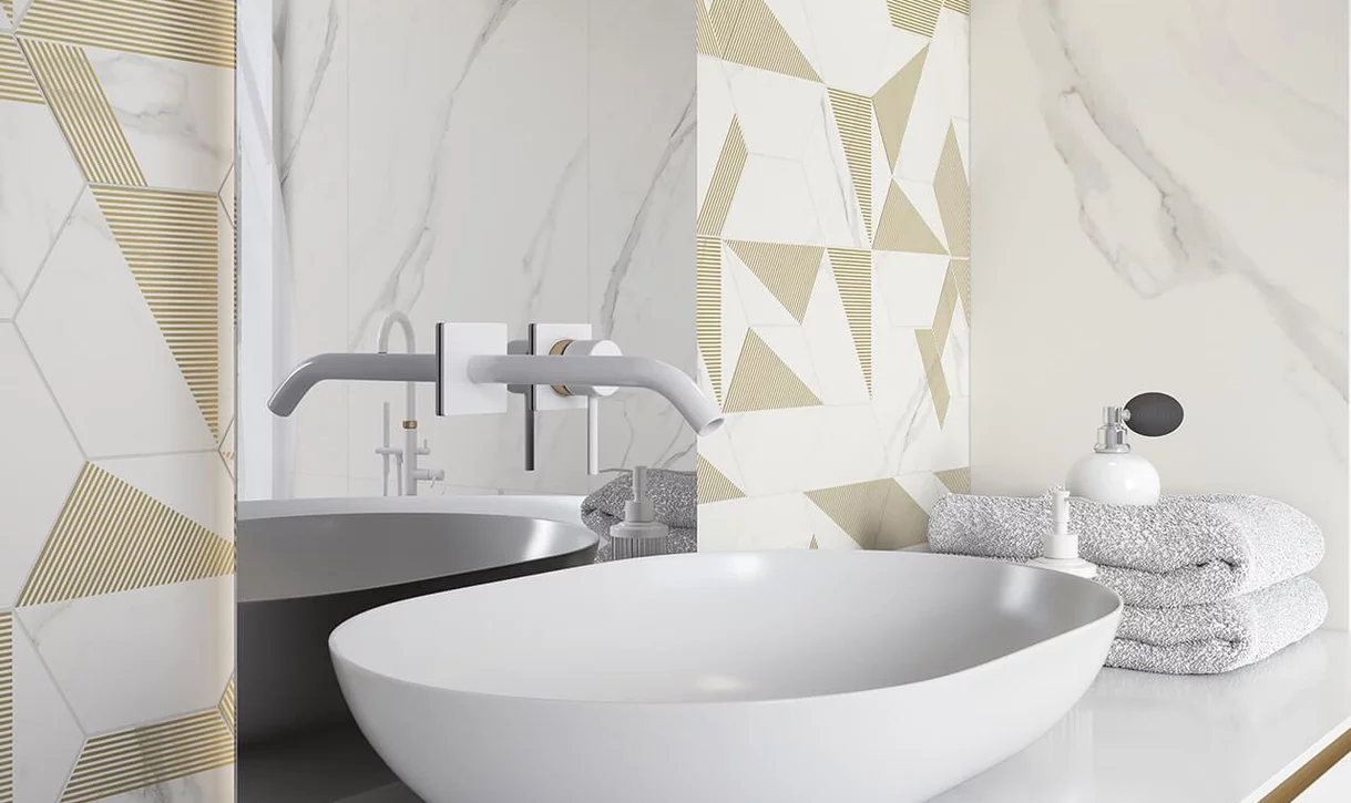 Nowoczesna łazienka z dużymi płytkami marmurowymi i geometrycznymi na ścianie oraz białą umywalką.