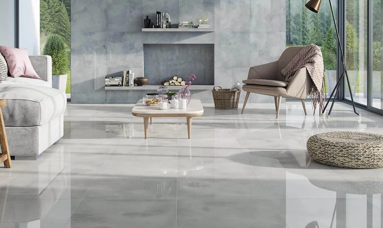 Nowoczesny salon z błyszczącymi płytkami marmurowymi na podłodze i teksturowanymi płytkami betonopodobnymi na ścianach.