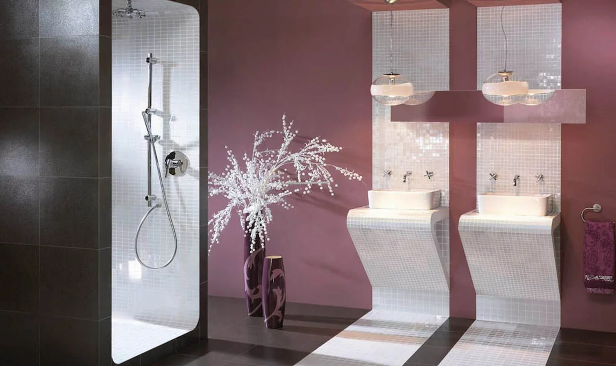 Nowoczesna łazienka z białymi płytkami mozaikowymi na umywalkach i w prysznicu oraz ciemną podłogą.