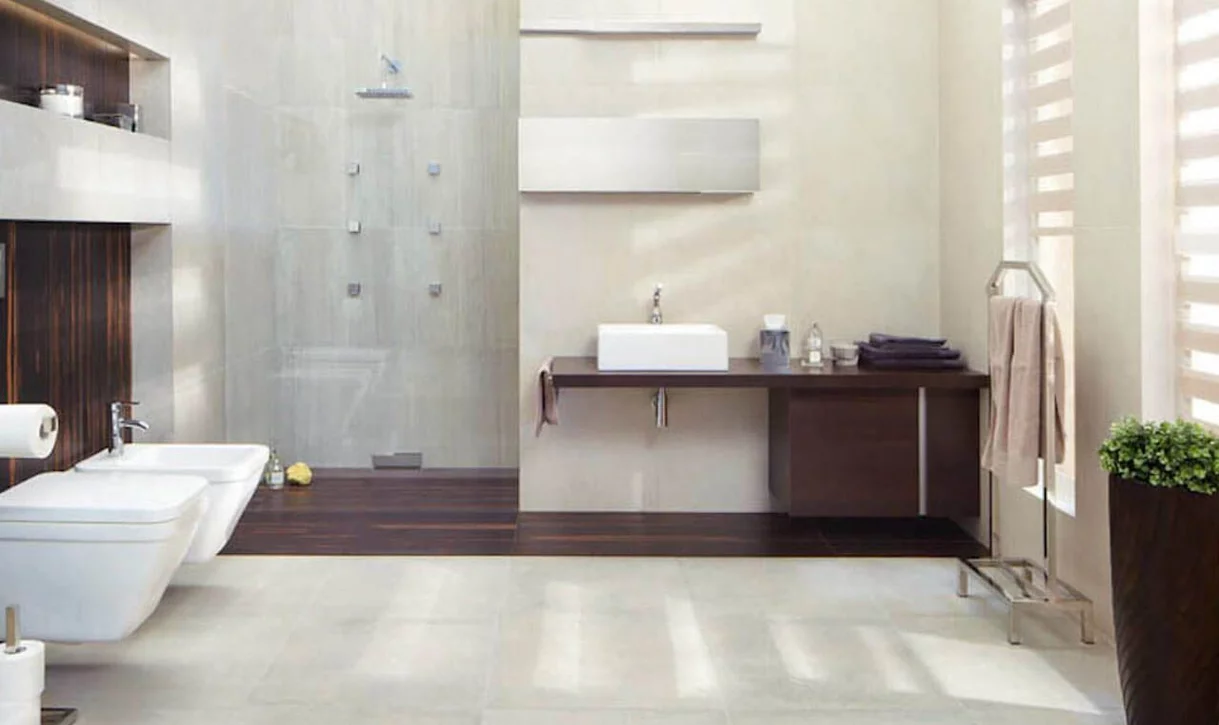Nowoczesna łazienka z dużymi płytkami kamieniopodobnymi i ciemnymi płytkami drewnopodobnymi.