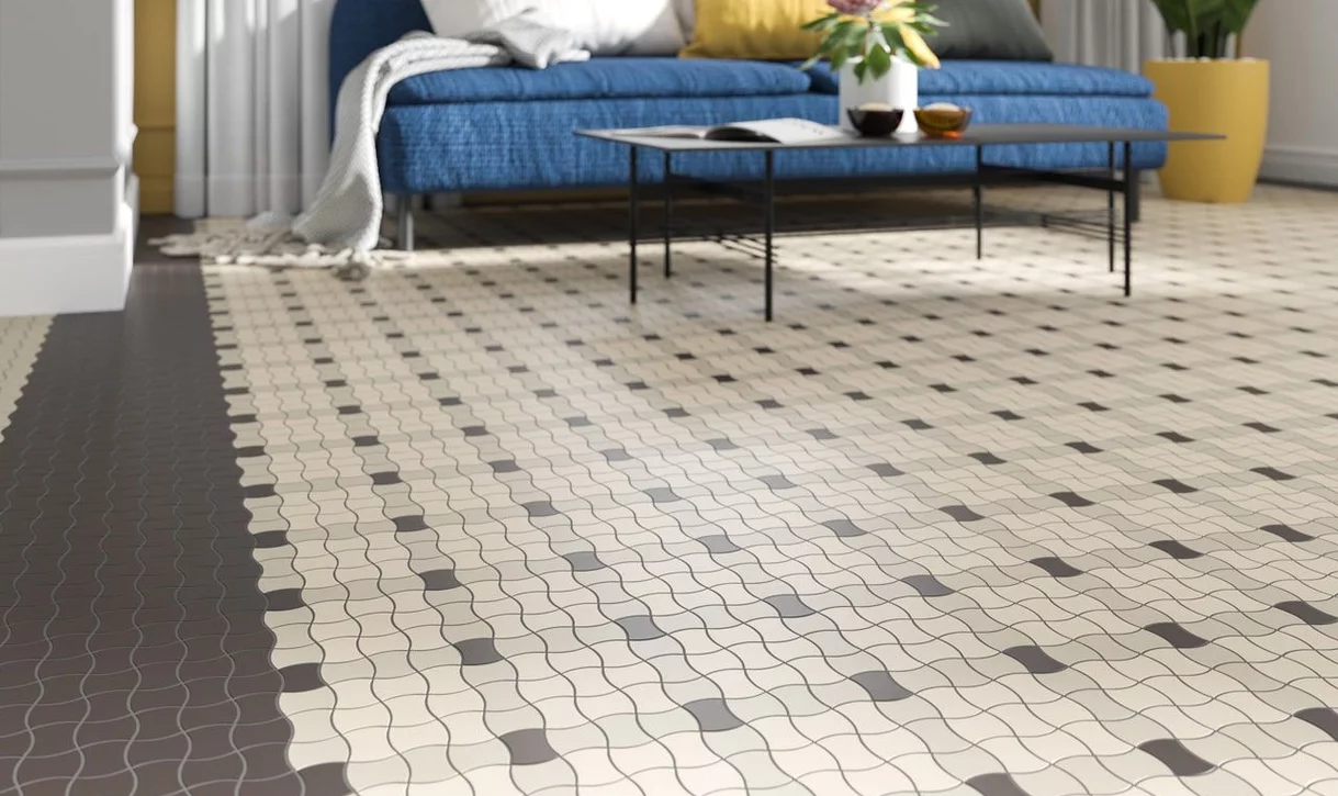 Salon z małymi matowymi płytkami ceramicznymi ułożonymi w geometryczny wzór oraz niebieską sofą i czarnym stolikiem.