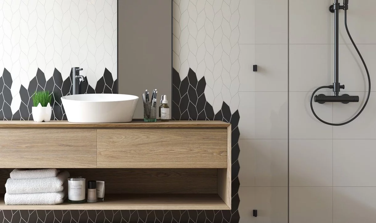 Nowoczesna łazienka z czarno-białymi sześciokątnymi płytkami na ścianie i jasnymi dużymi płytkami na sąsiedniej ścianie.