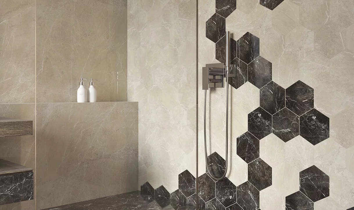 Nowoczesna łazienka z kremowymi i ciemnobrązowymi płytkami marmurowymi oraz heksagonalnym wzorem przy prysznicu.