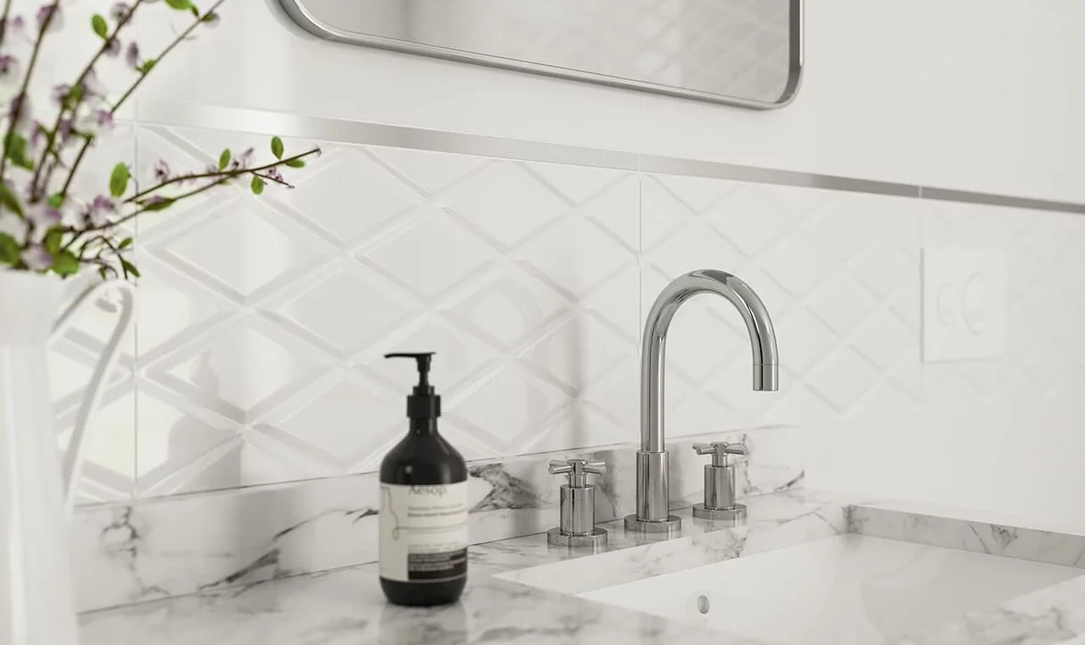 Minimalistyczna łazienka z białymi ceramicznymi płytkami ściennymi z diamentowym reliefem i marmurowym blatem.