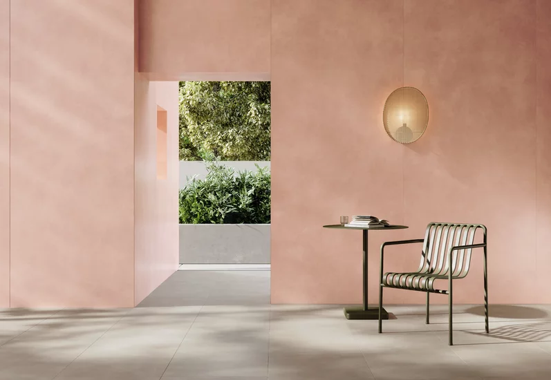 Minimalistyczne wnętrze z jasnoszarymi płytkami imitującymi beton z kolekcji Architeq i różowymi matowymi płytkami na ścianach.