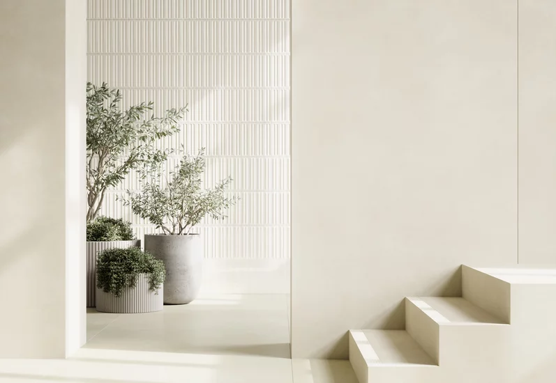 Minimalistyczne wnętrze z gładkimi płytkami imitującymi beton z kolekcji Architeq oraz zielenią.