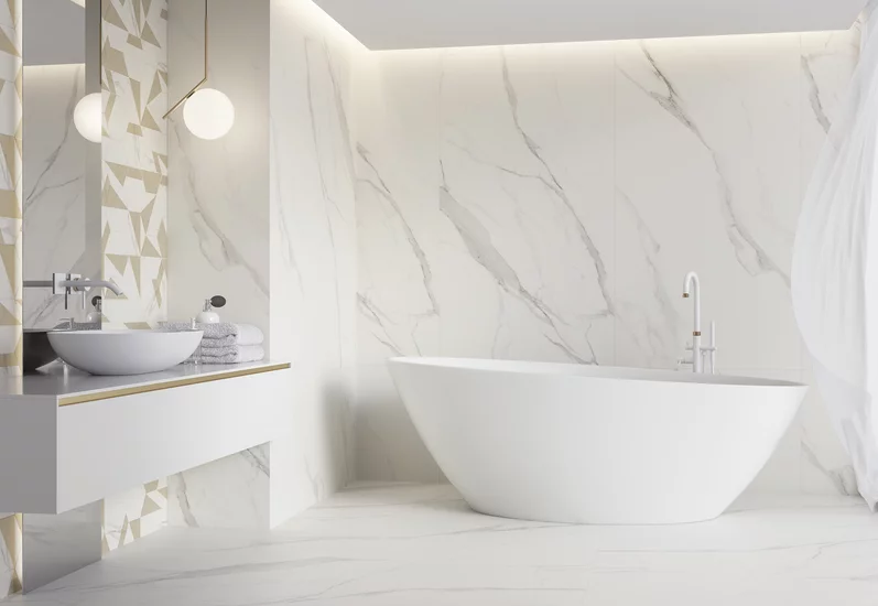 Minimalistyczna łazienka z marmurowymi płytkami inspirowanymi kamieniem z kolekcji Calacatta i wolnostojącą wanną.