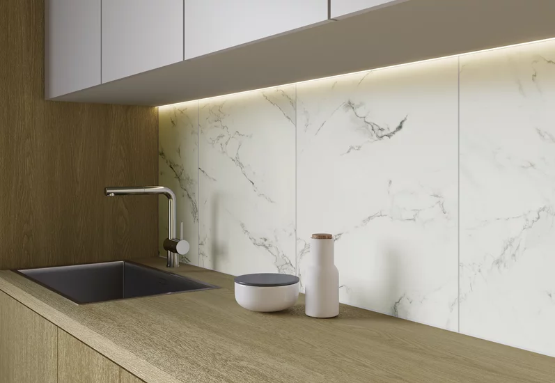 Minimalistyczna kuchnia z drewnopodobnym blatem i marmurowymi płytkami z kolekcji Carrastone.