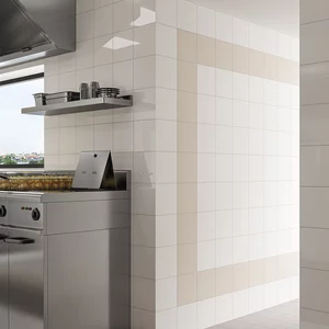 Nowoczesna kuchnia z błyszczącymi beżowo-białymi płytkami ceramicznymi z kolekcji Gamma colours i szarą podłogą.