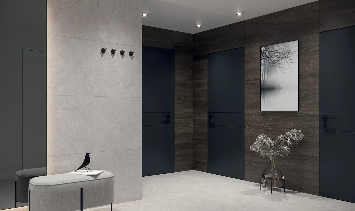 Minimalistyczny przedpokój z jasnoszarymi płytkami inspirowanymi kamieniem z kolekcji Lightstone i ciemnymi płytkami drewnopodobnymi.