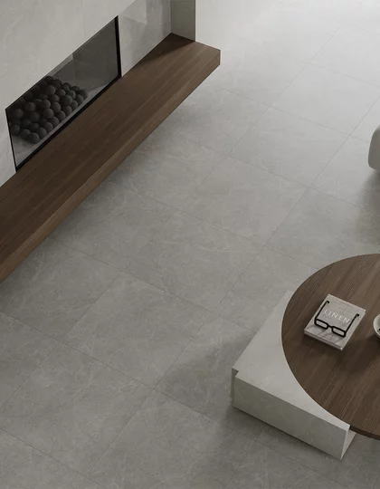 Minimalistyczny salon z dużymi płytkami inspirowanymi kamieniem z kolekcji Minirock i drewnianymi meblami.