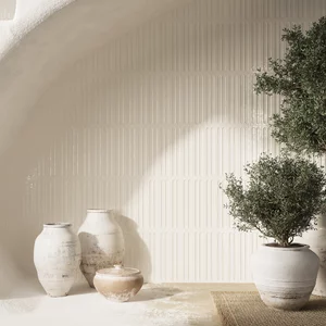 Minimalistyczne wnętrze z błyszczącymi ceramicznymi płytkami ściennymi z kolekcji Monpelli oraz rustykalną ceramiką i roślinami.