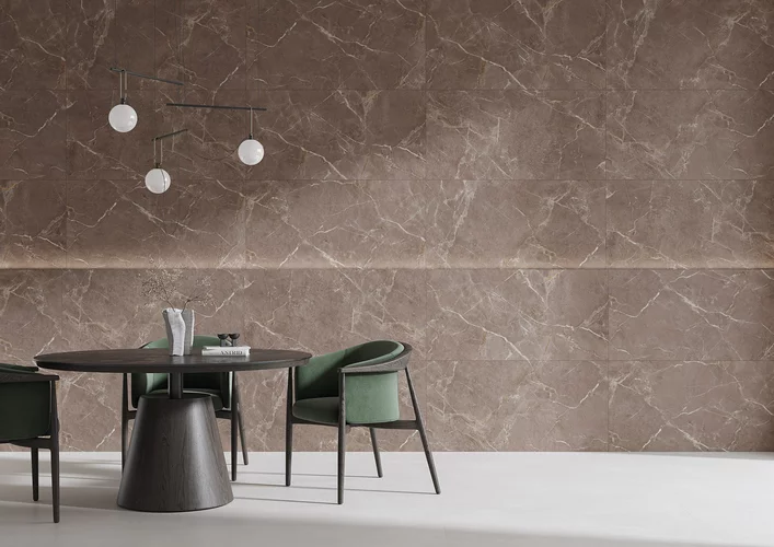 Modern dining room with Proud Champagne tiles, round table, and green chairs.
