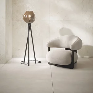 Jasny kącik wypoczynkowy w stylu nowoczesnym z płytkami Soft Harmony w odcieniu beżu i minimalistycznymi meblami.