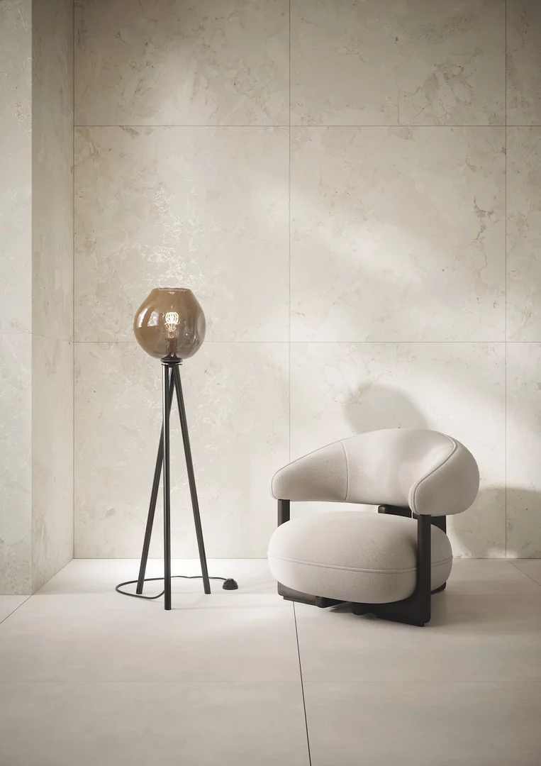 Jasny kącik wypoczynkowy w stylu nowoczesnym z płytkami Soft Harmony w odcieniu beżu i minimalistycznymi meblami.