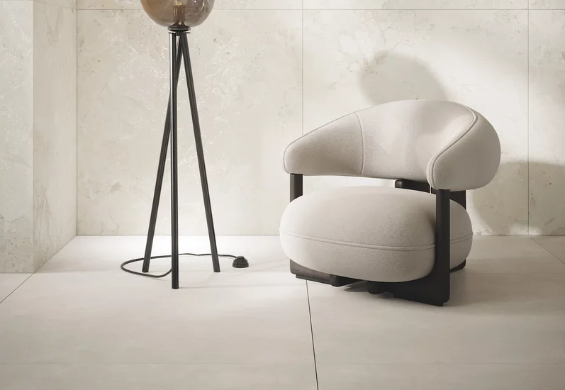 Jasny kącik wypoczynkowy w stylu nowoczesnym z płytkami Soft Harmony w odcieniu beżu i minimalistycznymi meblami.