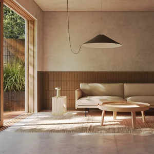 Minimalistyczny salon z brązowymi płytkami klinkierowymi z kolekcji Sundown na ścianie i płytkami imitującymi beton na podłodze.