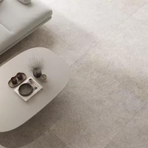 Elegancki salon z płytkami z kolekcji Urban Champagne. Jasna kanapa i spokojna, stonowana kolorystyka.