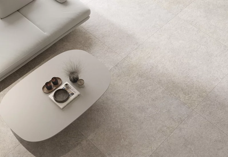 Elegancki salon z płytkami z kolekcji Urban Champagne. Jasna kanapa i spokojna, stonowana kolorystyka.