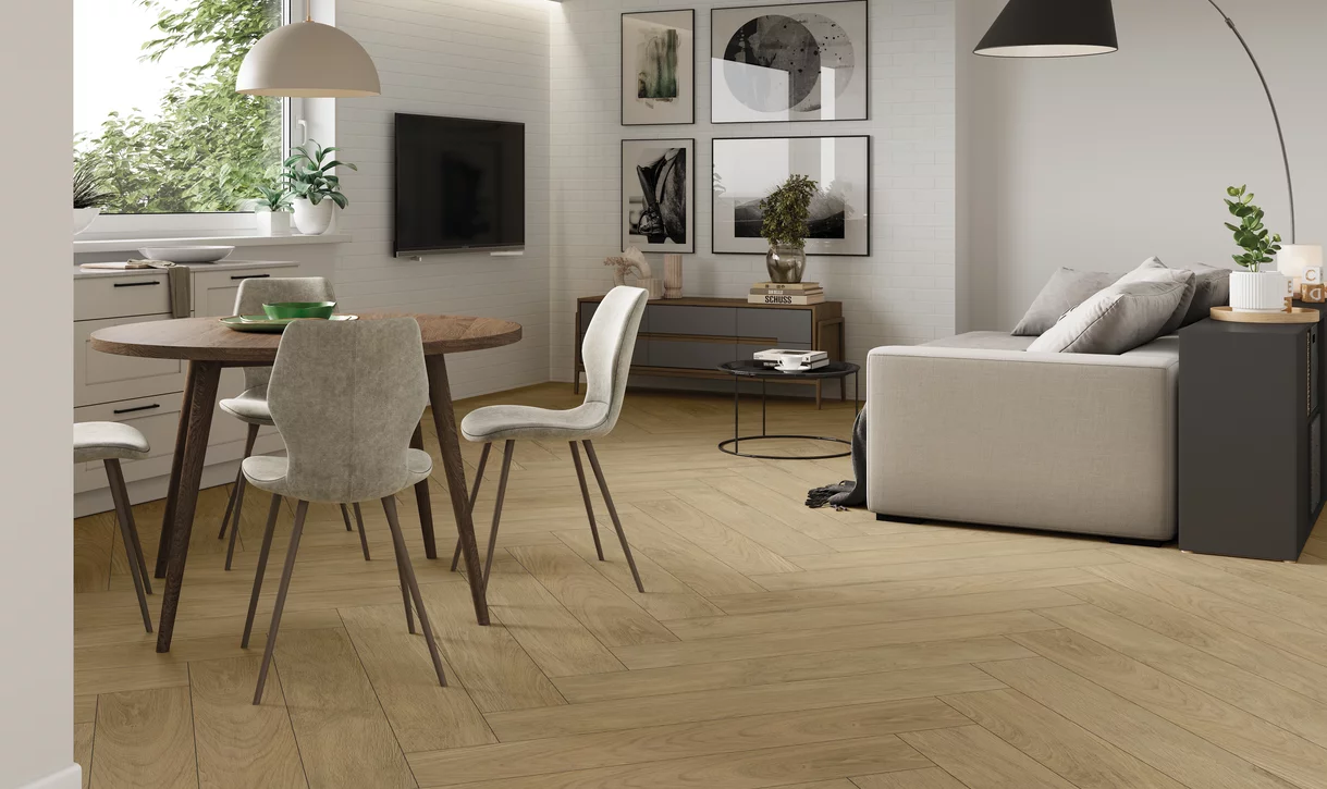 Salon i jadalnia z jasnymi płytkami drewnopodobnymi z kolekcji Warmwood i białą ścianą z prostokątnych płytek.