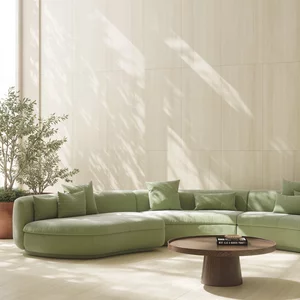 Przestronny salon z jasnymi płytkami Wave Desert, zieloną sofą w stylu modern i okrągłym drewnianym stolikiem.