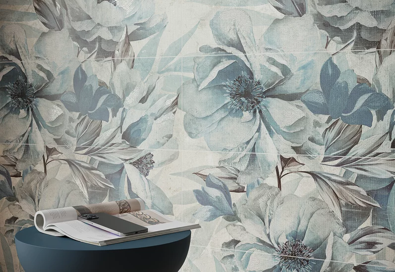 Ściana z dużymi płytkami ściennymi w kwiatowy wzór z kolekcji Wonder sky i niebieskim stołem.