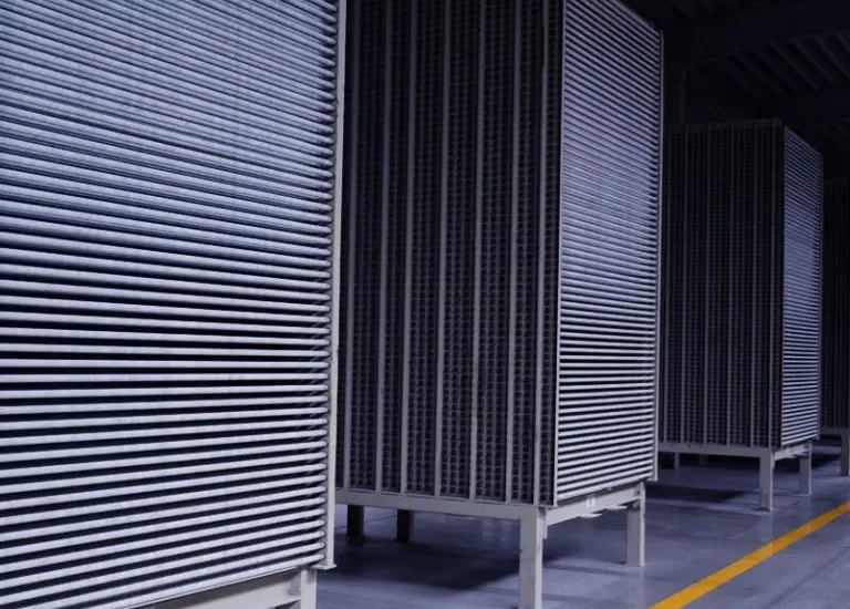 Rząd dużych przemysłowych filtrów powietrza w nowoczesnym obiekcie z polerowaną podłogą.