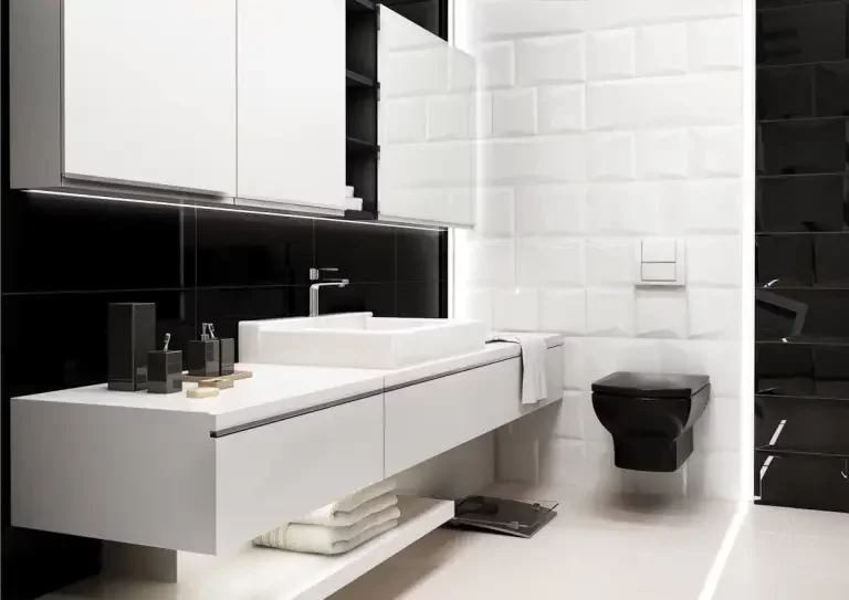 Nowoczesna łazienka z czarnymi błyszczącymi i białymi płytkami typu metro oraz białą wiszącą umywalką i czarną toaletą.