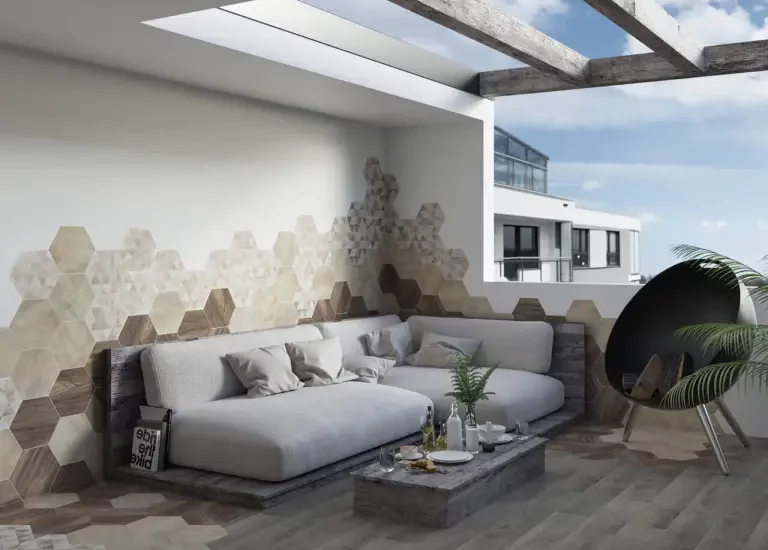 Nowoczesny taras z heksagonalnymi płytkami drewnopodobnymi i kamieniopodobnymi na białej ścianie oraz meblami wypoczynkowymi.