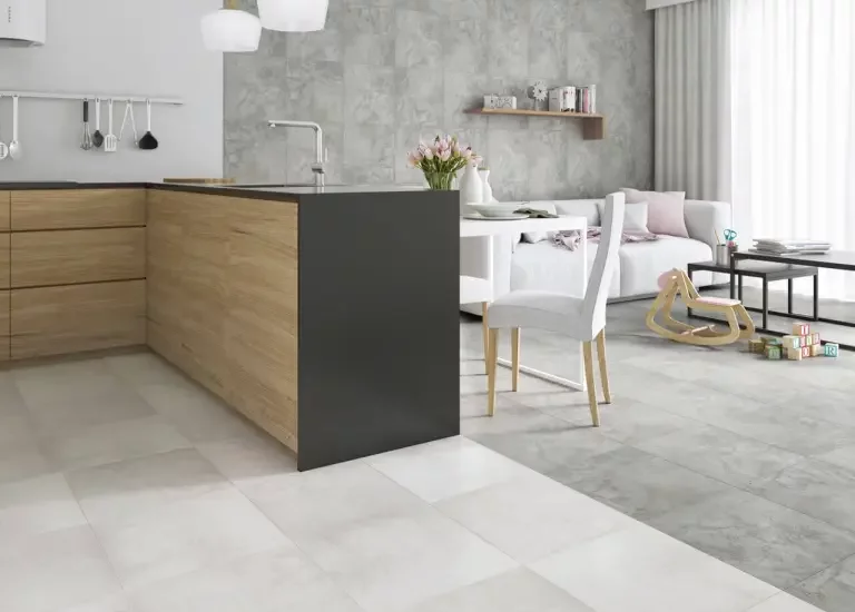 Nowoczesna przestrzeń dzienna z drewnopodobnymi płytkami na szafkach i szarymi płytkami kamieniopodobnymi na podłodze i ścianach.