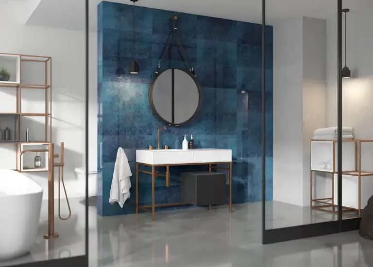 Nowoczesna łazienka z granatową ścianą z płytek kamieniopodobnych i podłogą z płytek imitujących beton.