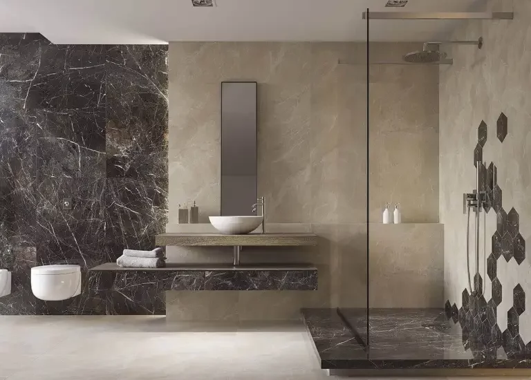 Nowoczesna łazienka z beżowymi płytkami kamieniopodobnymi i ciemnymi sześciokątnymi płytkami marmurowymi.