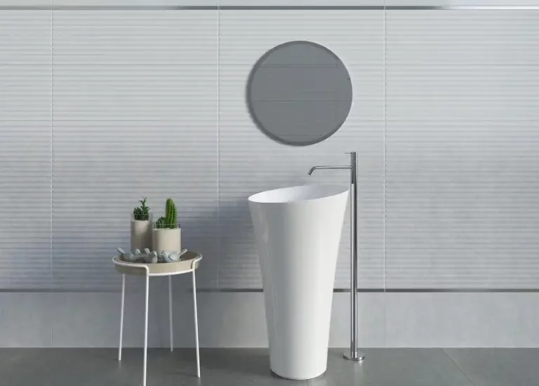 Minimalistyczna łazienka z jasnoszarymi płytkami imitującymi beton na podłodze i białymi ryflowanymi płytkami na ścianach.