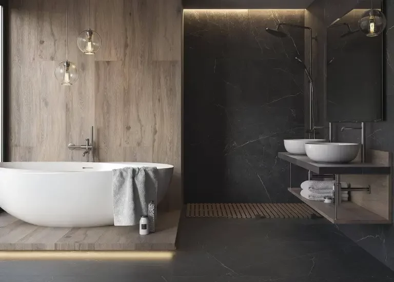 Nowoczesna łazienka z drewnopodobnymi płytkami na podwyższeniu i ciemnymi płytkami marmurowymi na podłodze i w prysznicu.