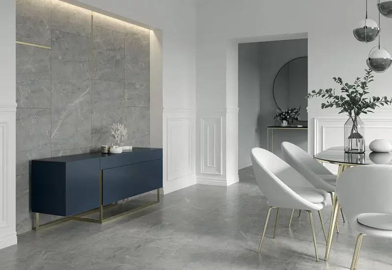 Minimalistyczna jadalnia z dużymi szarymi płytkami kamieniopodobnymi na podłodze i ścianie akcentowej.