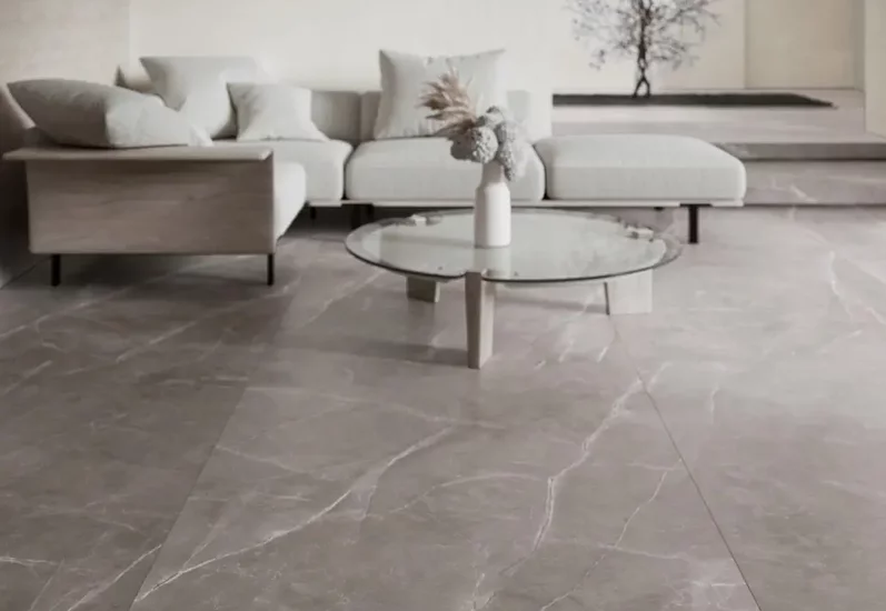 Minimalistyczny salon z dużymi płytkami marmurowymi na podłodze i nowoczesnymi meblami.